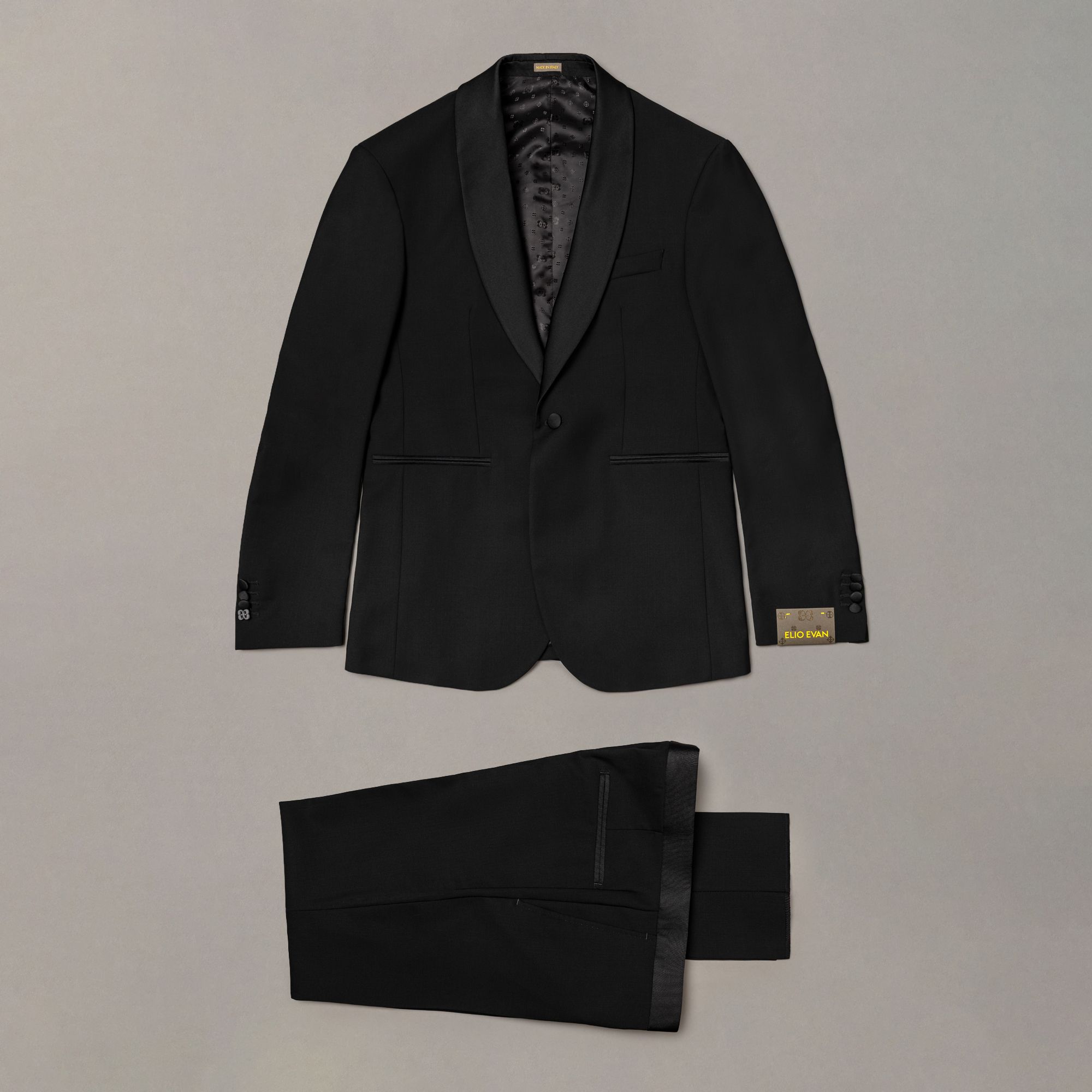 Smoking nero in lana vergine con linea slim e costruzione formale Made in Italy. Premium menswear firmato Elio Evan.