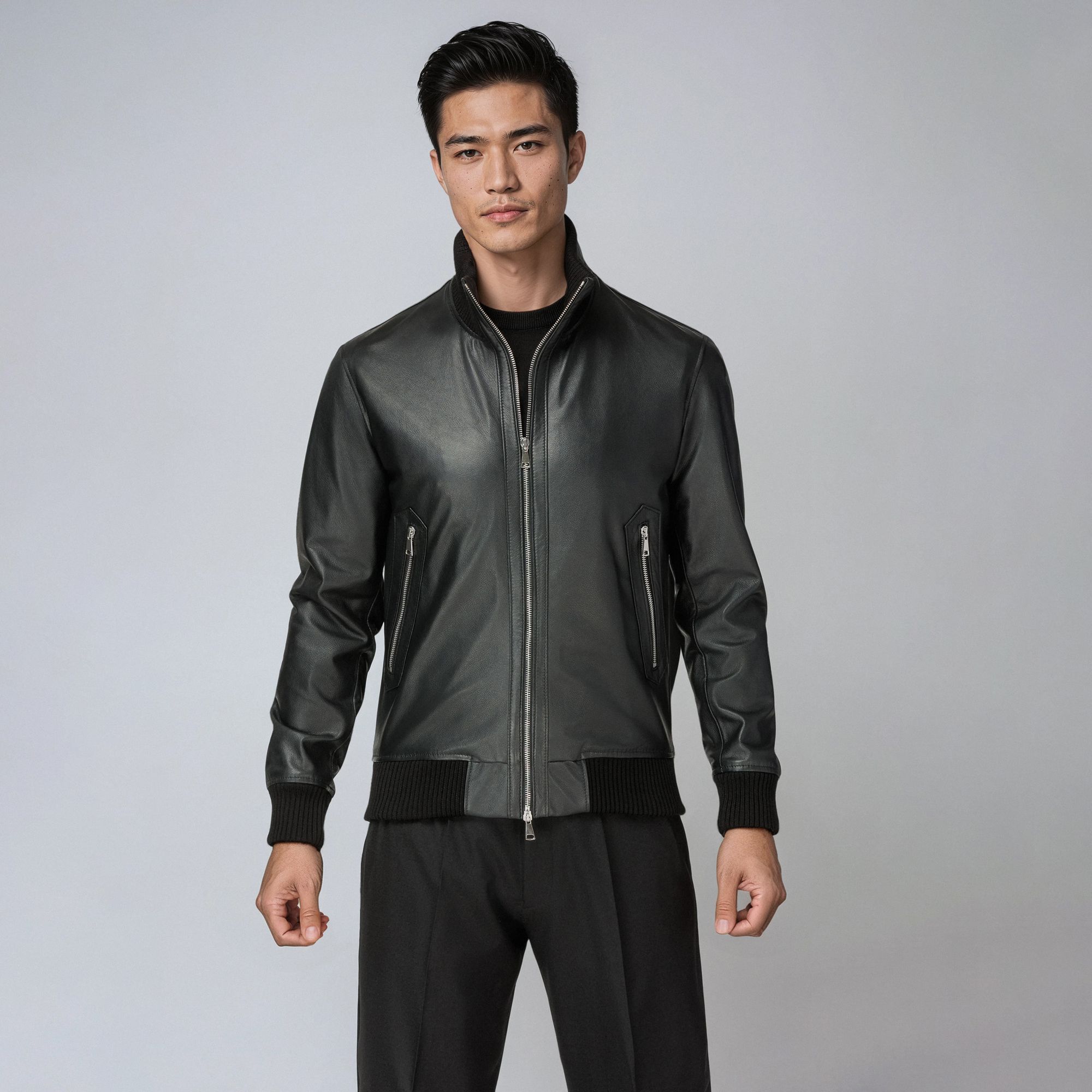 Uomo con total look Elio Evan: bomber in pelle nera e pantaloni neri.