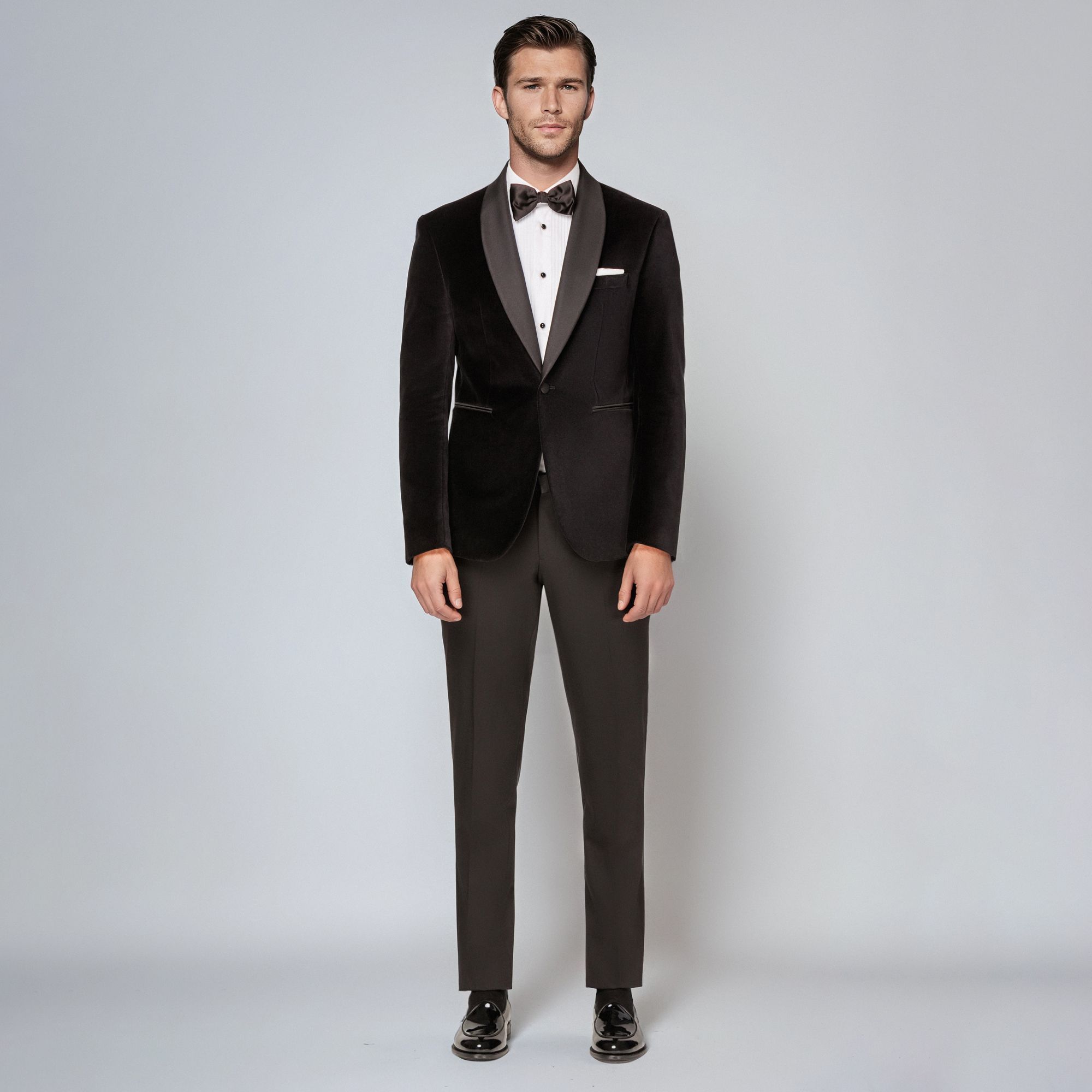 Uomo con total look Elio Evan: smoking in velluto nero con revers in raso, camicia bianca e papillon.