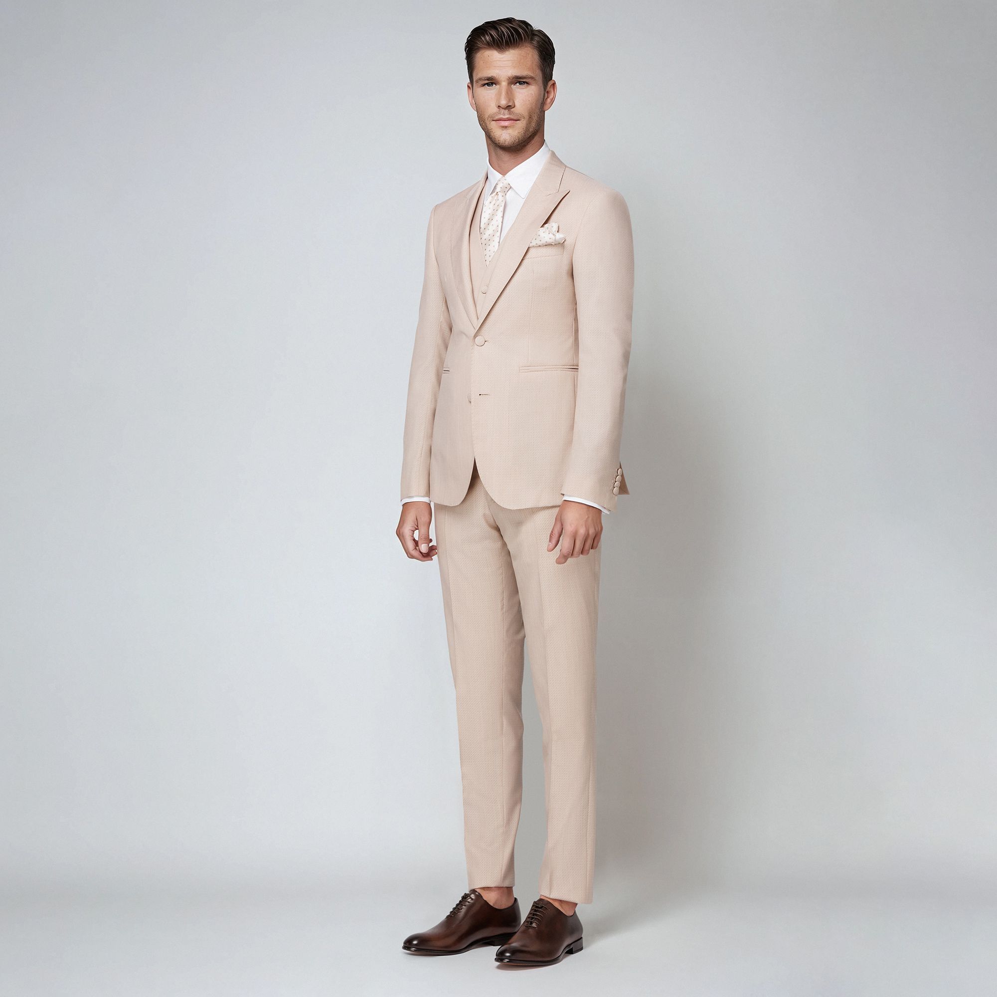 Abito tre pezzi in jacquard lana-seta beige. Giacca monopetto con rever a lancia, bottoni rivestiti e costruzione sartoriale. Made in Italy.
