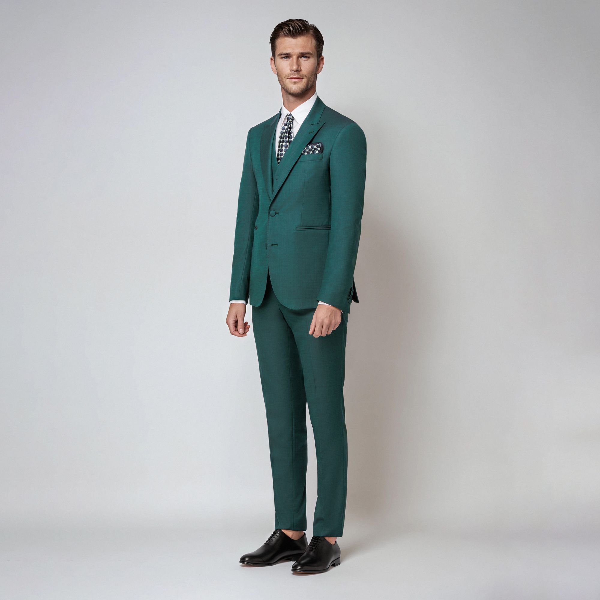 Abito tre pezzi in lana-seta verde iridescente. Giacca monopetto con rever a lancia, bottoni rivestiti e costruzione sartoriale. Made in Italy.