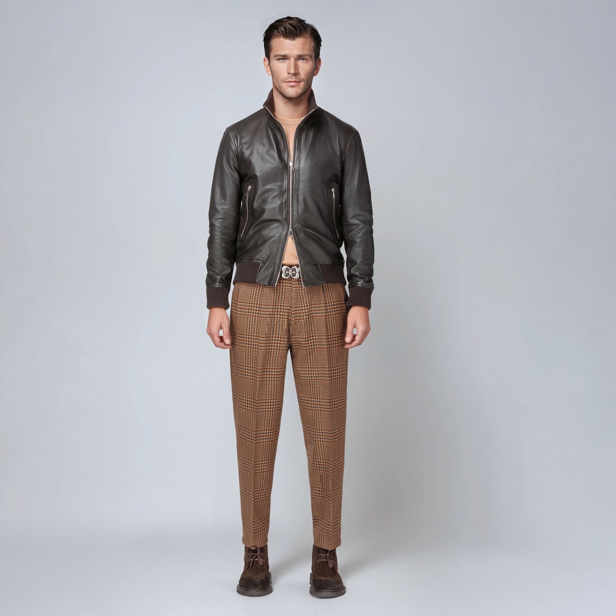 Uomo con bomber marrone aperto e pantaloni scozzesi – total look Elio Evan.